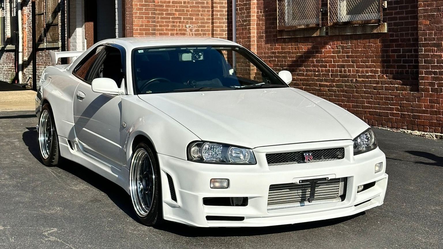White Nissan Skyline R34 with a fresh ceramic coating parked outside Auto Customs